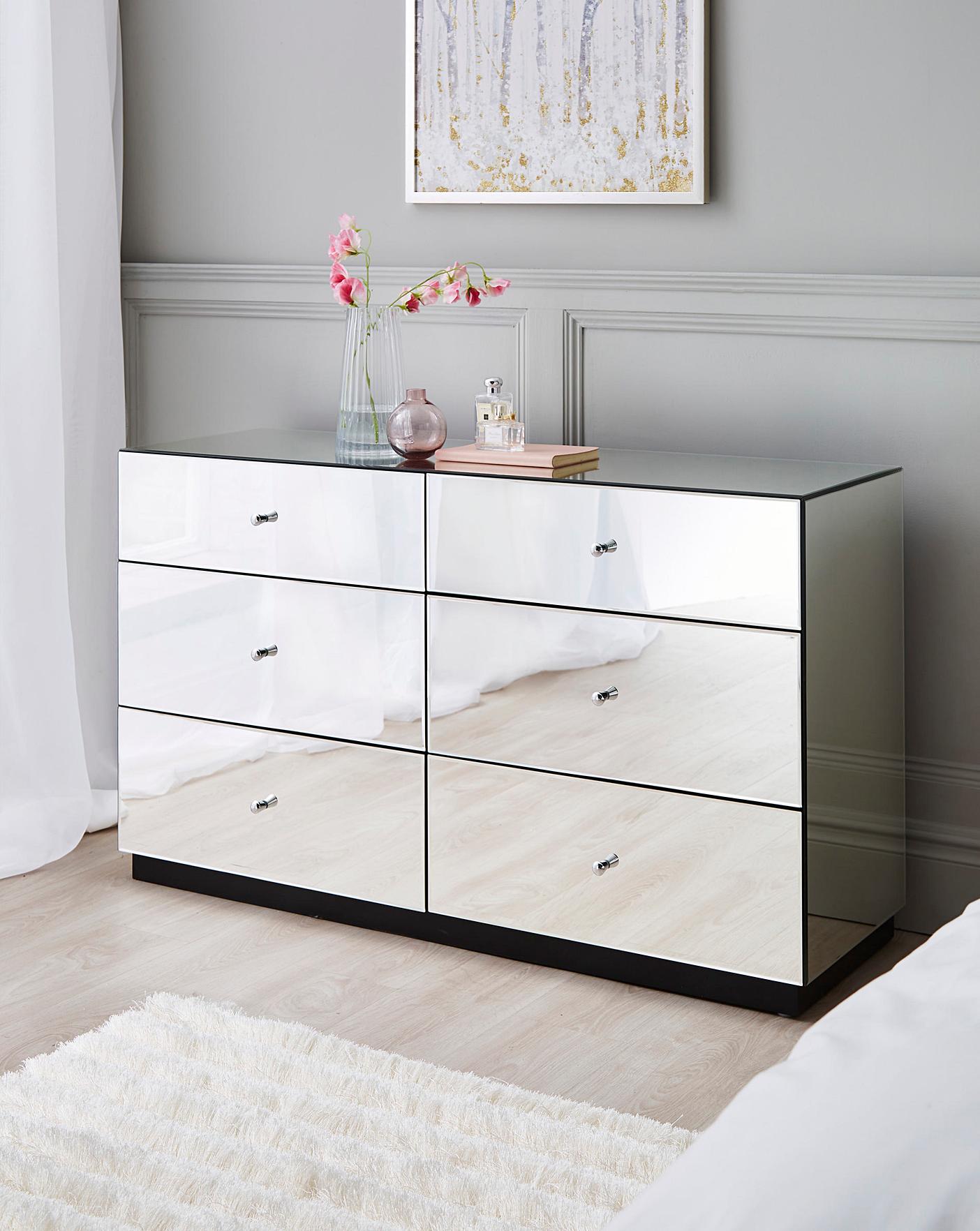 Chest of DrawersTransform your bedroom into a luxurious haven with our Glass Mirror Chest of 6 Drawers. Its mirrored surface adds depth and elegance to your interior, while the six Luxe Living InteriorsGlass Mirror Chest