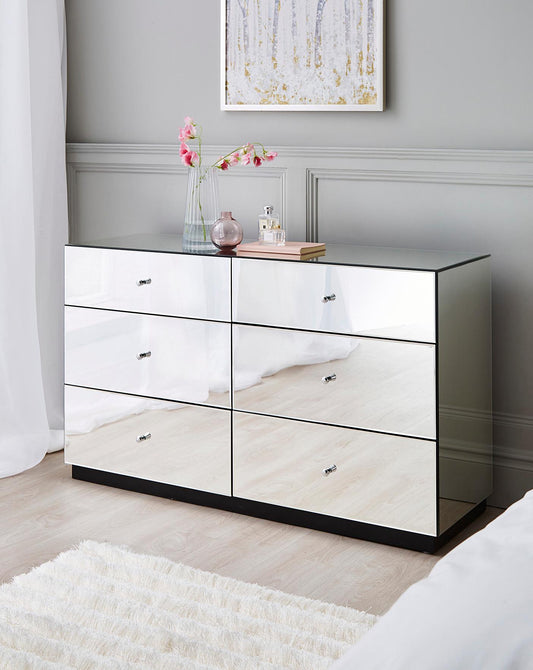 Chest of DrawersTransform your bedroom into a luxurious haven with our Glass Mirror Chest of 6 Drawers. Its mirrored surface adds depth and elegance to your interior, while the six Luxe Living InteriorsGlass Mirror Chest